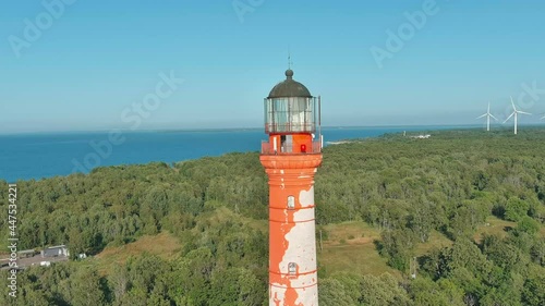 Flying around the lighthouse of Pakri with wind generators on background and sea