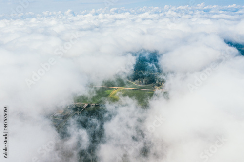 High flight in the cumulus clouds over agricultural fields in summer.