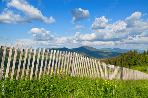 Wooden fence on top of mountains, bright blue sky. Ukraine, Carpathians.