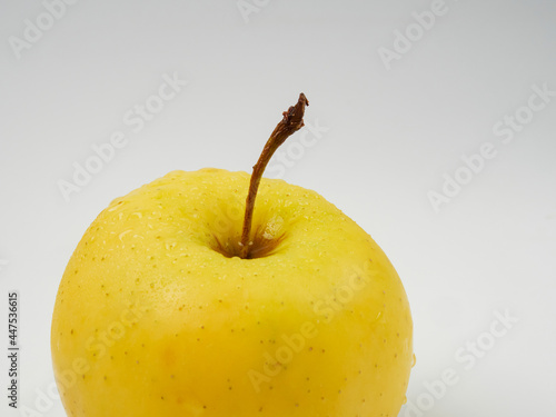 Fresh yellow apple with water drops, isolated on a white background