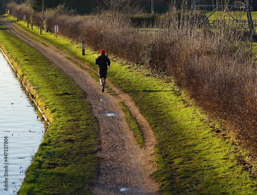 Lone jogger on a canal towpath © simonXT2