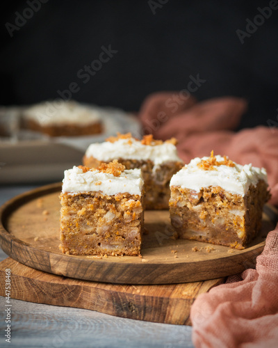 Carrot cake with butter cream on a wooden table. Cake with cream cheese on a wooden plate in rustic style