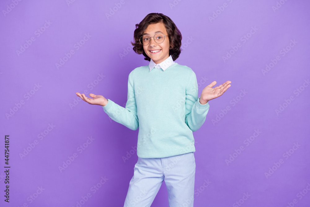 Photo of little cute brunet boy shrug shoulders wear blue sweater spectacles isolated on purple background Photo of little cute brunet boy shrug shoulders wear blue sweater spectacles isolated on purple background
