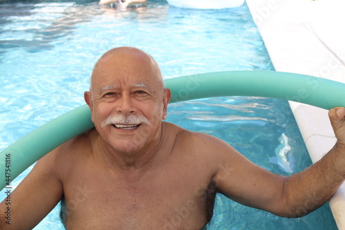 Senior man exercising in swimming pool photo