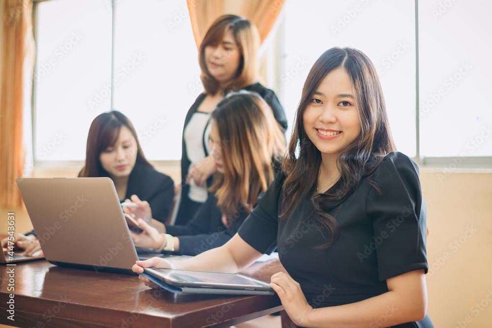 Portrait of a beautiful authentic satisfied business woman looking at camera with team at behind. Concept for leadership and successful startup millennial. Portrait of a beautiful authentic satisfied business woman looking at camera with team at behind. Concept for leadership and successful startup millennial.
