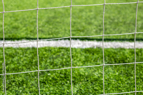 The grid of football soccer gates is a close-up on the background of a green football soccer field.