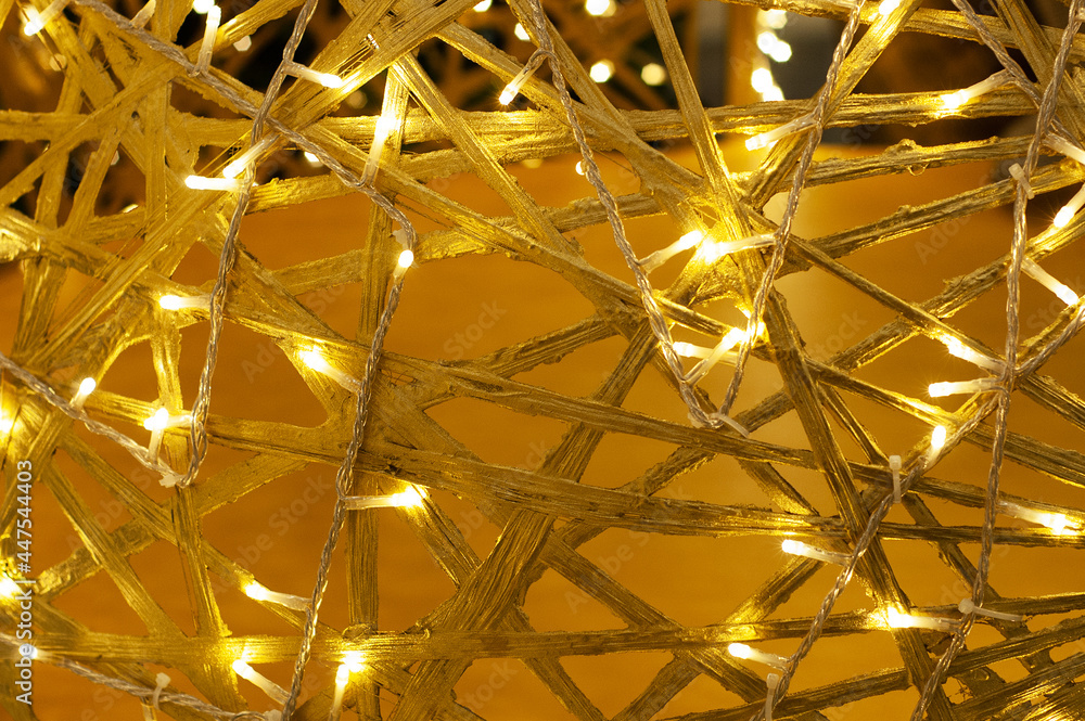 Fototapeta premium Yellow background intertwined wooden branches with lights.