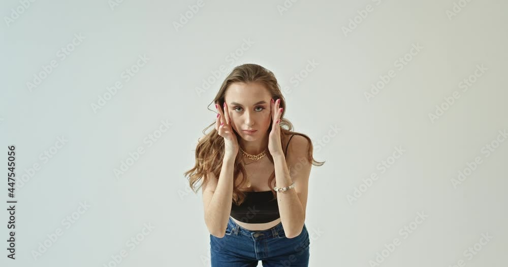 Girl stylishly dressed with beautiful makeup and long hair looks into the camera corrects makeup touches hair tightens clothes spins like in front of a mirror Girl stylishly dressed with beautiful makeup and long hair looks into the camera corrects makeup touches hair tightens clothes spins like in front of a mirror