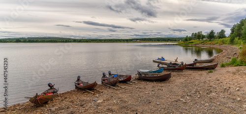 panorama view of many wooden motorboats used for salmon fishing on the banks of the Tornionjoki River in Finnish Lapland photo