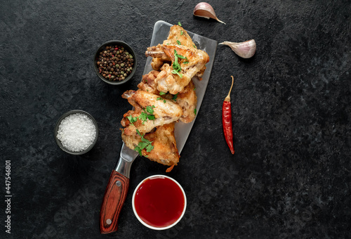 grilled chicken wings on a knife on a stone background