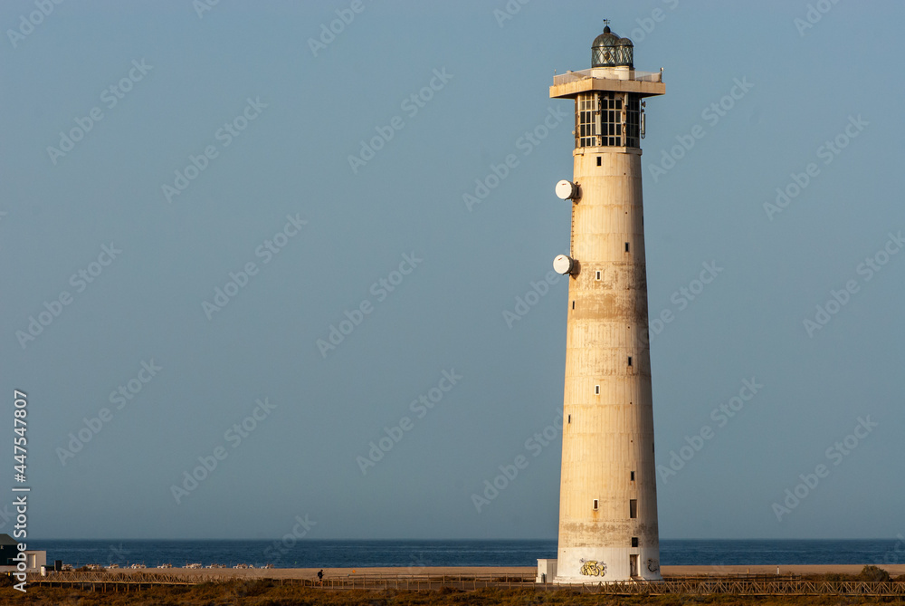 White lighthouse at dawn by the sea