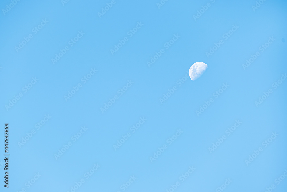 Half moon during day with clear blue sky Half moon during day with clear blue sky