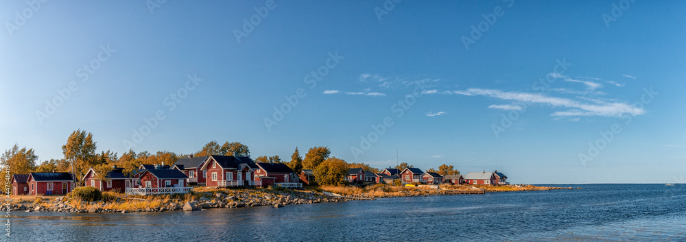 Fototapeta premium idyllic Baltic Sea panorama landscape with red cottages on the shoreline under a blue sky in autumn