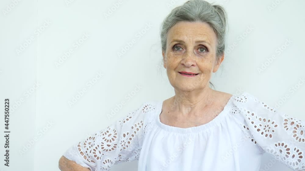 Beautiful old grandmother with grey hair and face with wrinkles is grimacing while looking at the camera on white background, mothers day, happy retirement Beautiful old grandmother with grey hair and face with wrinkles is grimacing while looking at the camera on white background, mothers day, happy retirement