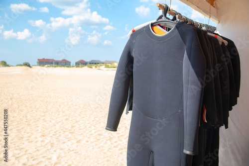 Diving suit to dry on the beach. Wetsuit on the shore. Swimming equipment