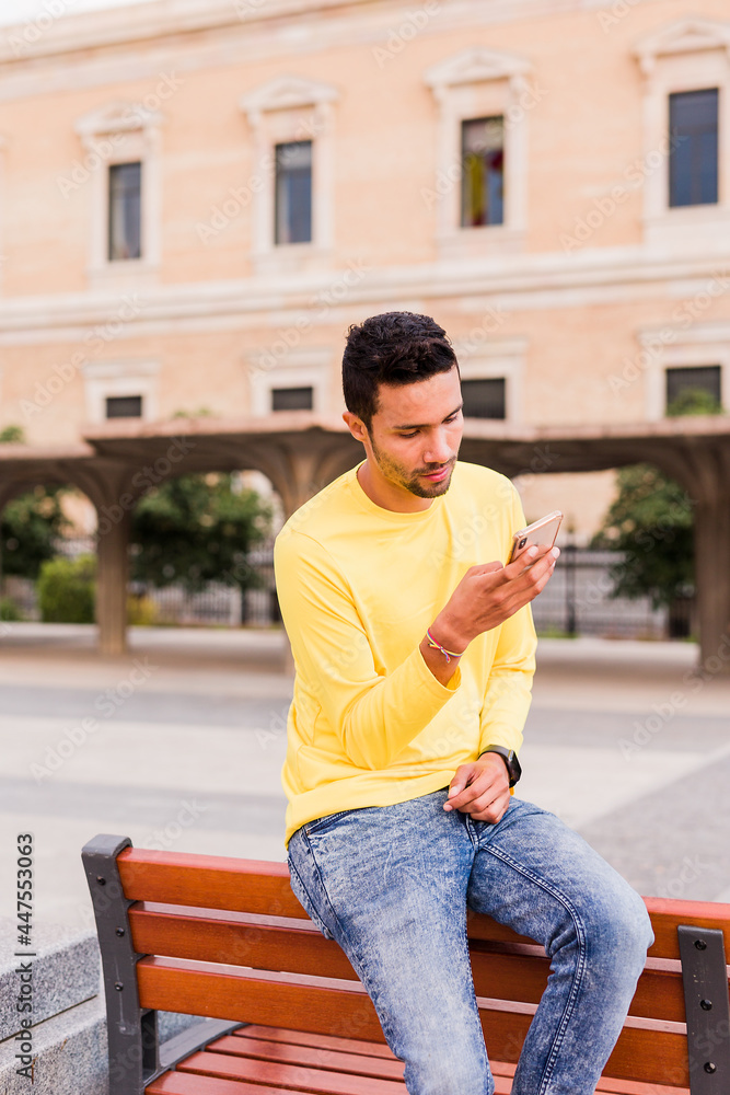 Obraz premium A young latin america man chatting online on smartphone technology. yellow