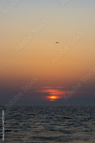Ein Sonnenuntergang und ein Flugzeug am Meer in der Nähe von Rom, Italien