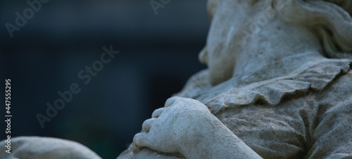 Fragment of an ancient stone statue of sad and desperate woman on tomb as a symbol of death and the end of human life. Selective focus on hand.