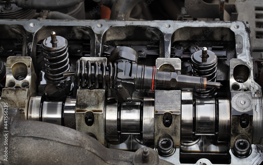 Detail of modern diesel engine repair, closeup of injectors in cylinder head with camshaft