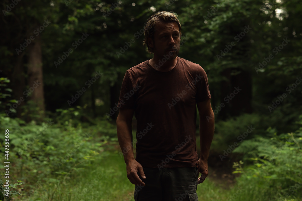 Blonde man with a stubble beard in a brown t-shirt walking on a Blonde man with a stubble beard in a brown t-shirt walking on a