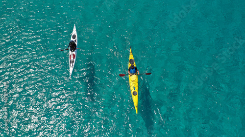 Aerial drone photo of team of young women practice on sport kayak in tropical exotic bay with emerald crystal clear sea