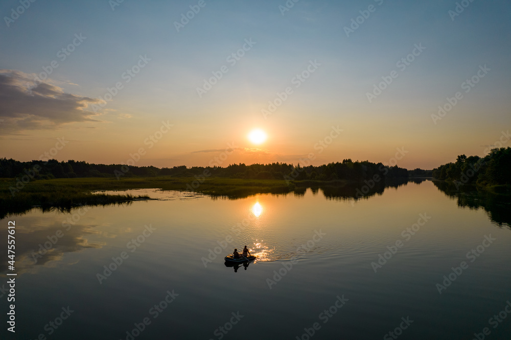 Aerial view of inflatable boat at sunset river