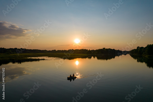 Aerial view of inflatable boat at sunset river