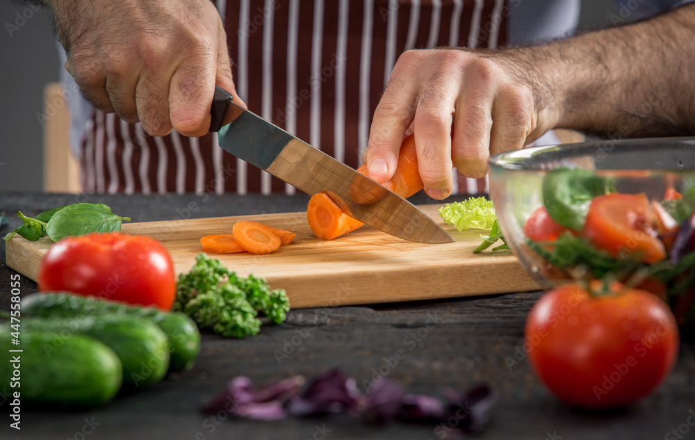 Male hands cutting vegetables for salad