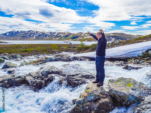 Traveler tourist at river vavatn lake with snow Hemsedal Norway. photo