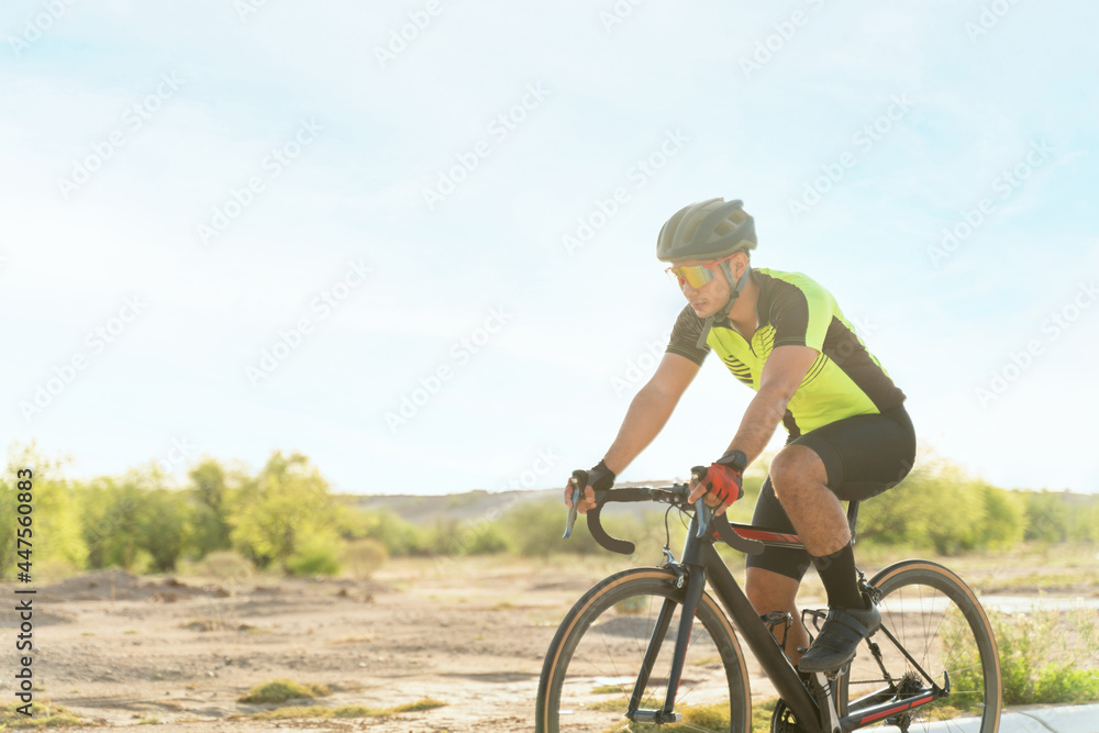 Side view of an athlete riding a bicycle outdoors
