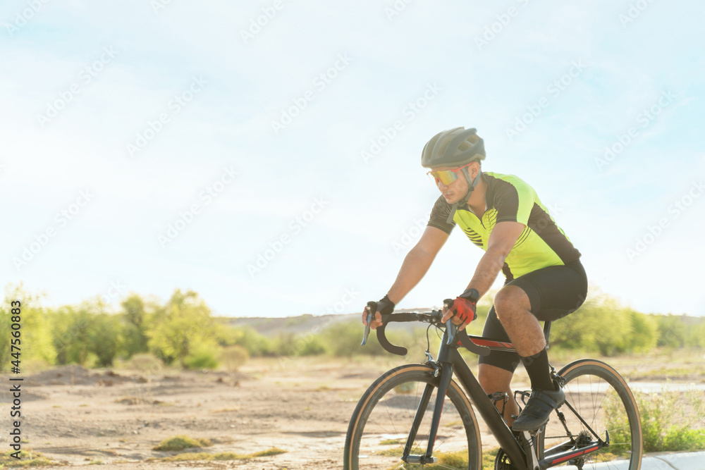 Side view of an athlete riding a bicycle outdoors Side view of an athlete riding a bicycle outdoors