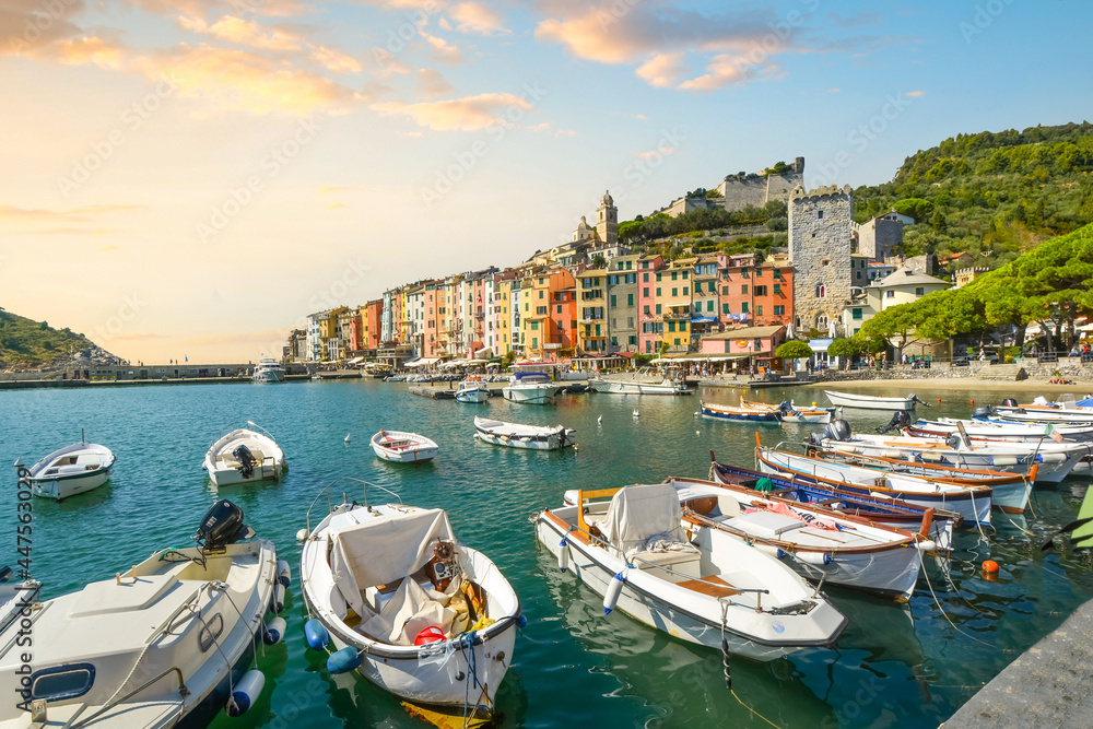 Boats line the harbor of the colorful, touristic Italian city of Portovenere, Italy, along the Ligurian Coast of the Italian Riviera at sunset.