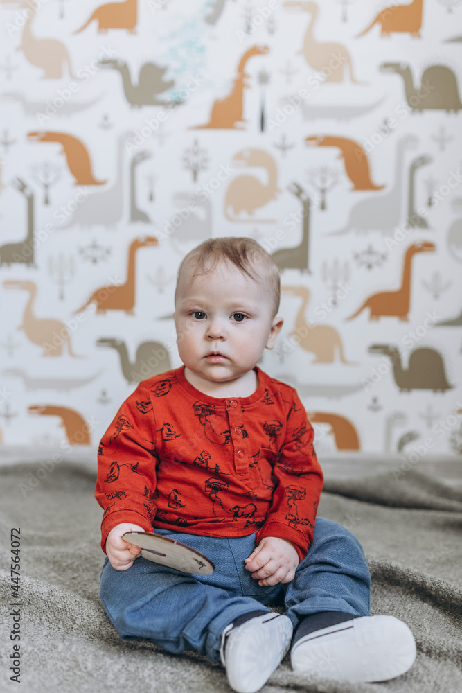 baby child sitting on the floor and playing with his toys in the children's room baby child sitting on the floor and playing with his toys in the children's room