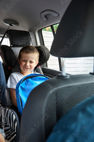 Happy charming boy goes with his dad, parents in the car to school. Children return to school, schoolchildren's everyday life. vertical photo © Elena Medoks