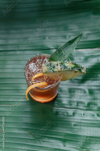 Top down view of planter's punch cocktail on a banana leaf