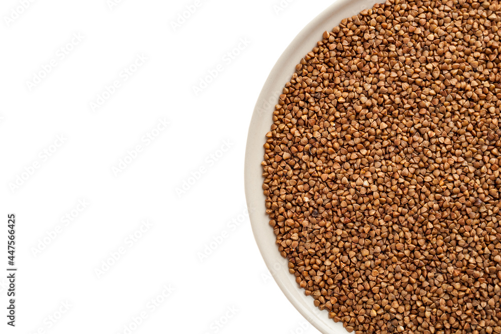 Buckwheat grits poured into a cup, buckwheat porridge, buckwheat kernels not boiled, dietary vegan food Buckwheat grits poured into a cup, buckwheat porridge, buckwheat kernels not boiled, dietary vegan food