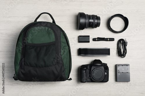 Professional photography equipment and backpack on wooden table, flat lay