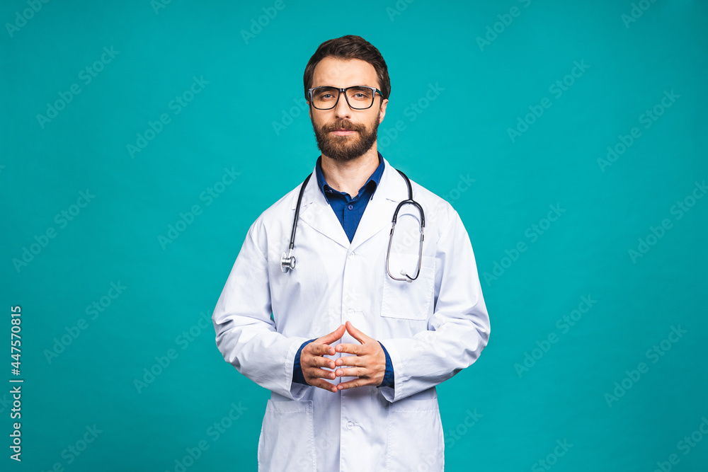 Portrait young bearded doctor with stethoscope over neck in medical coat standing against isolated blue background. Portrait young bearded doctor with stethoscope over neck in medical coat standing against isolated blue background.