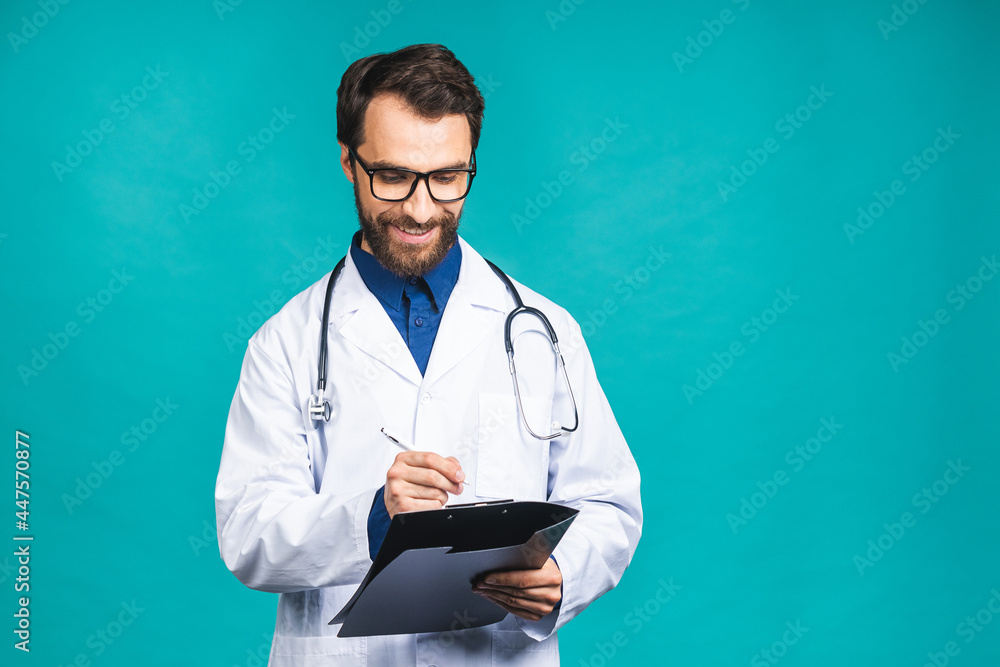 Happy smiling bearded doctor man writing recipe on clipboard, isolated over blue background. Happy smiling bearded doctor man writing recipe on clipboard, isolated over blue background.