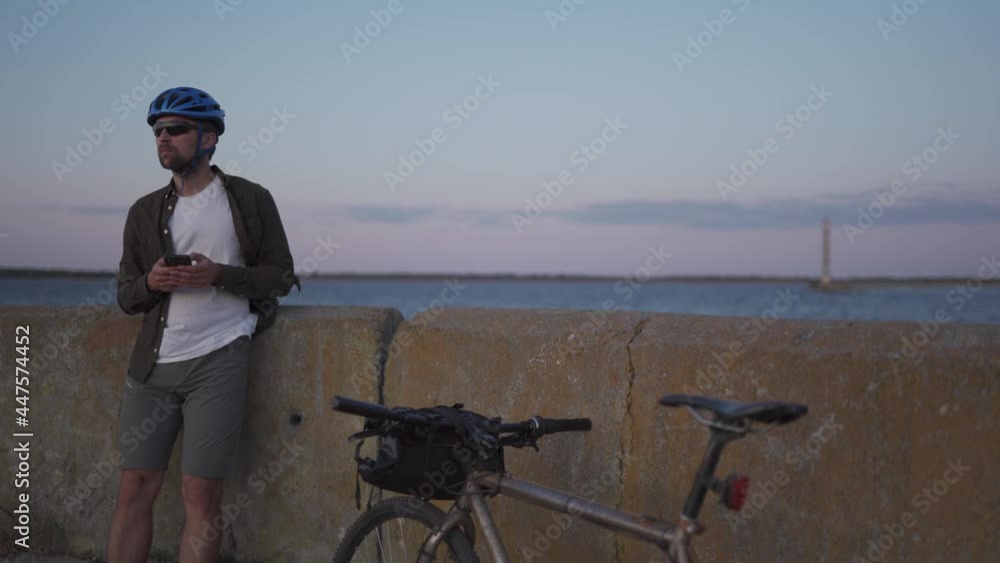custom made wallpaper toronto digitalMale cyclist resting on promenade by sea and uses smartphone at sunset. Healthy active lifestyle traveler on bike. Bicyclist stands coast seaview with bicycle build route, looks at map on phone.