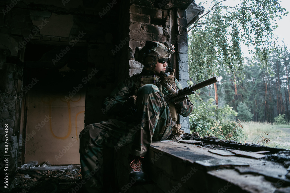 Soldier talking on the walkie-talkie inside the building, military concept Soldier talking on the walkie-talkie inside the building, military concept