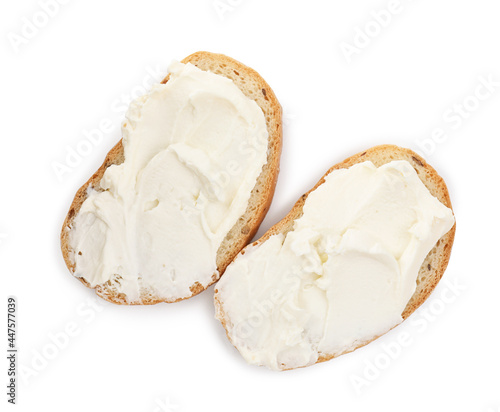 Bread with cream cheese on white background, top view