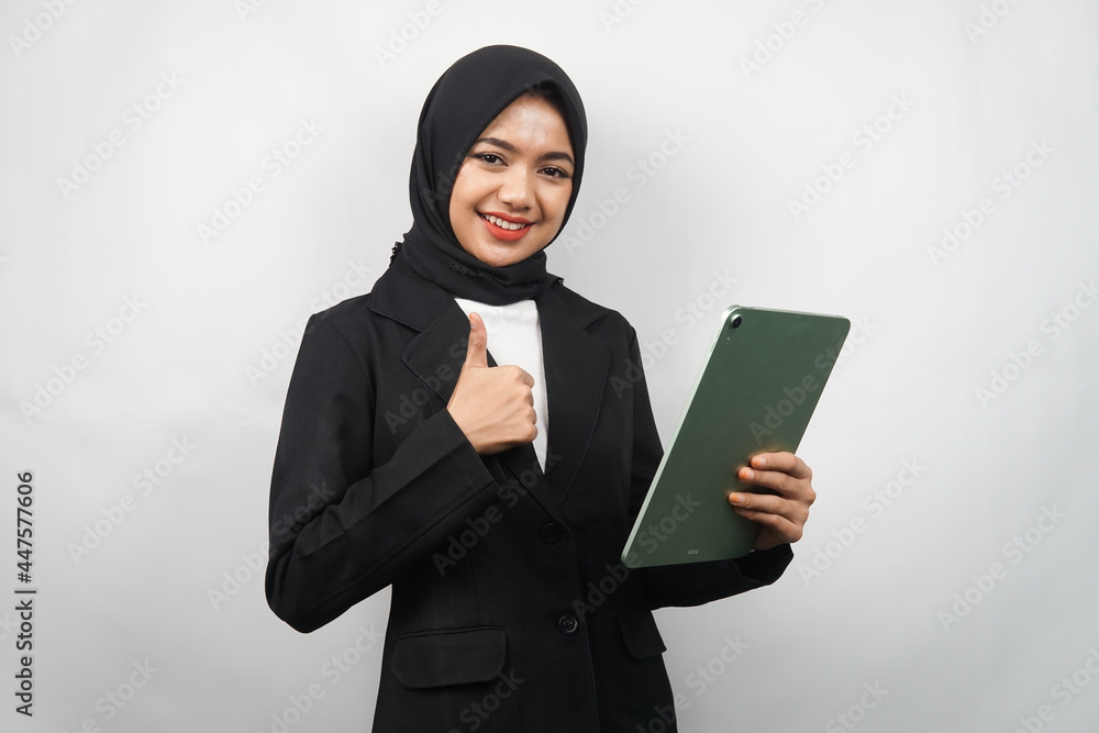 Beautiful young asian muslim business woman confident and smiling, with hands holding tablet, time to work, productive time, isolated on gray background Beautiful young asian muslim business woman confident and smiling, with hands holding tablet, time to work, productive time, isolated on gray background