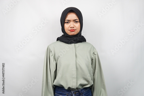 Beautiful young asian muslim woman pouting, sad, unhappy, isolated on gray background