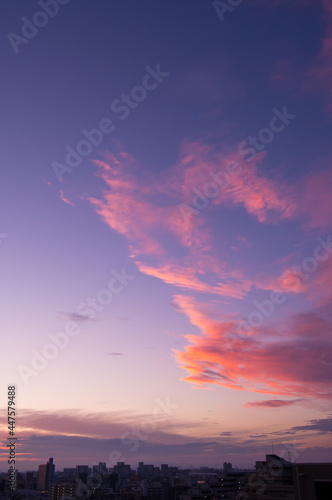 都市の夕暮れ。神戸市街より大阪方面を臨む。オレンジ色に染まる雲。 © 宮岸孝守