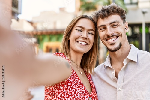 Young hispanic couple smiling happy making selfie by the camera at the city.
