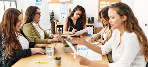 Group of young businesswomen smiling happy working at the office.