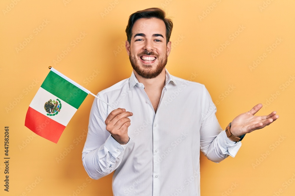 Handsome caucasian man with beard holding mexican hat celebrating achievement with happy smile and winner expression with raised hand Handsome caucasian man with beard holding mexican hat celebrating achievement with happy smile and winner expression with raised hand