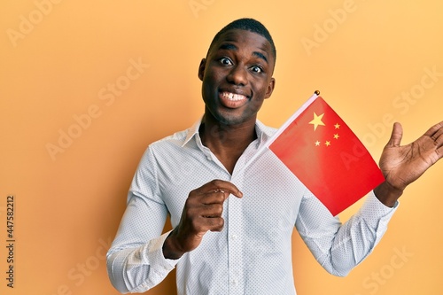 Photography Young african american man holding china flag celebrating achievement with happy
