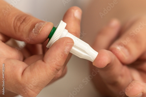 Blood sugar measuring: A person stings a finger to get blood for blood glucose analysis